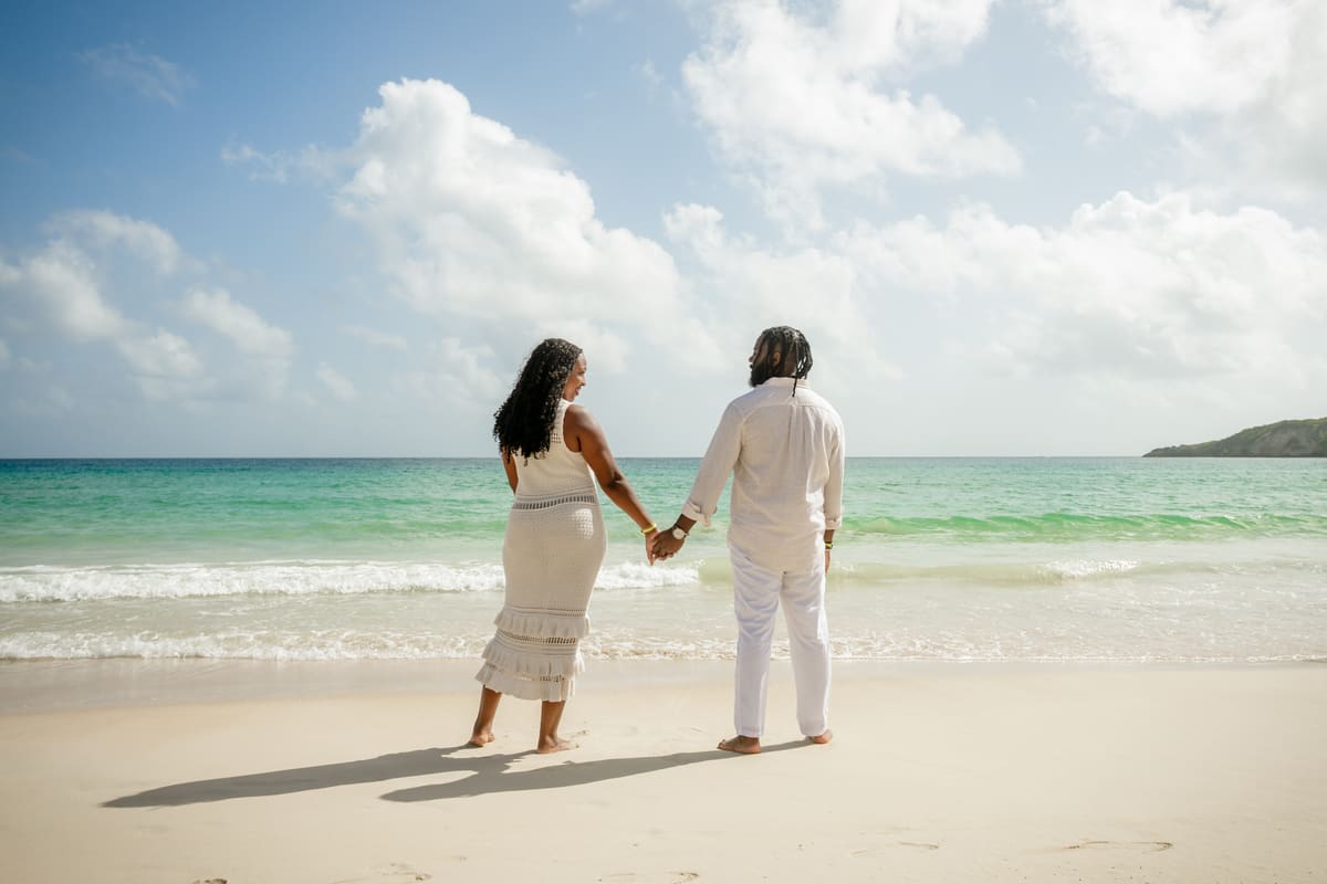 Doug and Sam on a beach, hand in hand, walking toward the water